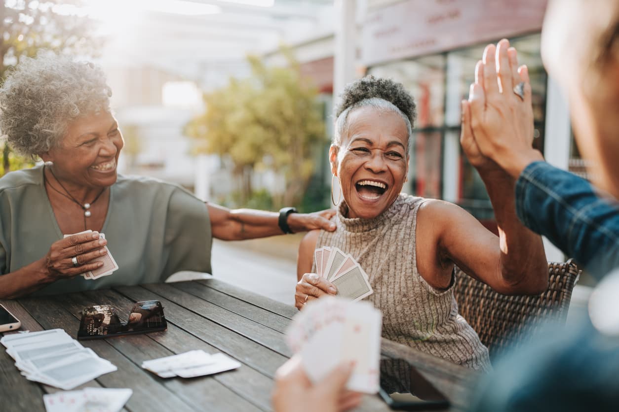 Senior friends enjoying a card game together, laughing and having a great time